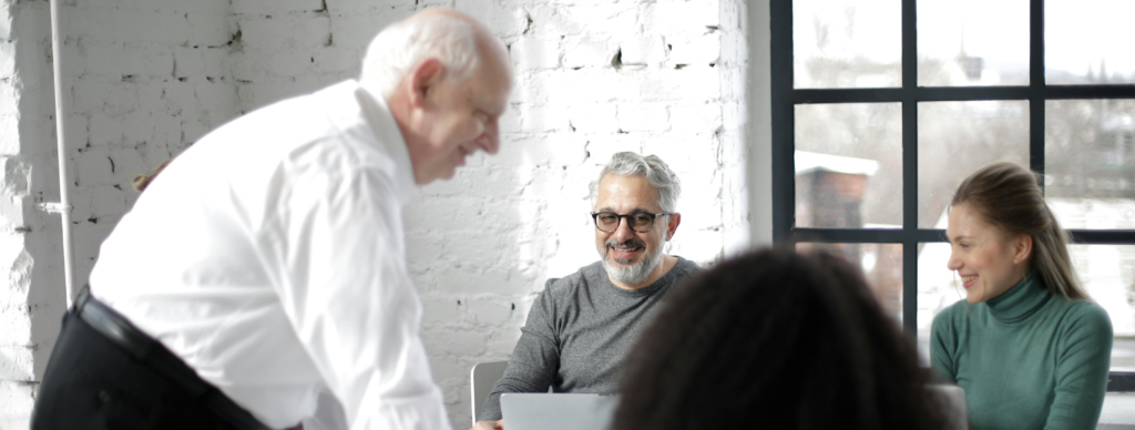 business team gathered around a table discussing questions to ask when selling a business