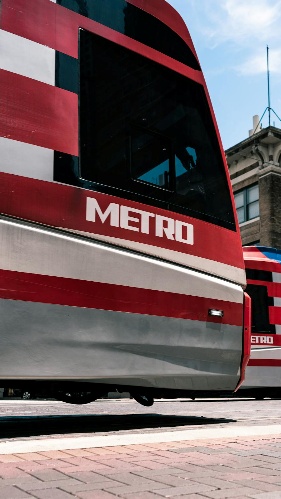 : Close-up of a red and white Houston METRO light rail train, representing the movement and precision required to navigate due diligence when learning how to sell a small business in Houston. 